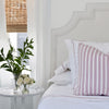 pink and white striped pillow on bed with luxury bed linens with pale pink stripe along with faux white roses
